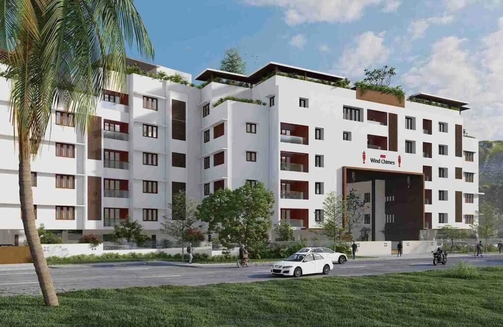 Modern white apartment building with "Wind Chimes" signage, palm tree and cars