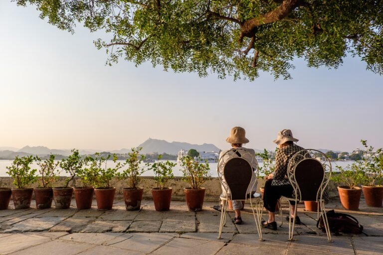 Elderly couple enjoying a scenic view of a lake and mountains in Vellore, Tamil Nadu.